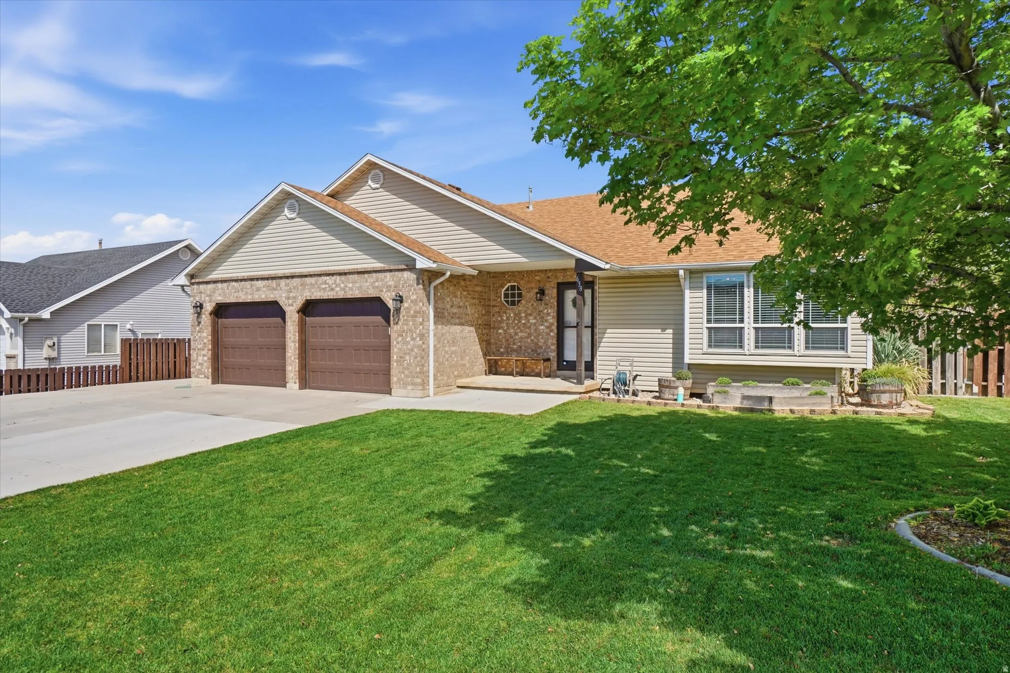Ranch-style house featuring an attached garage, concrete driveway, and brick siding