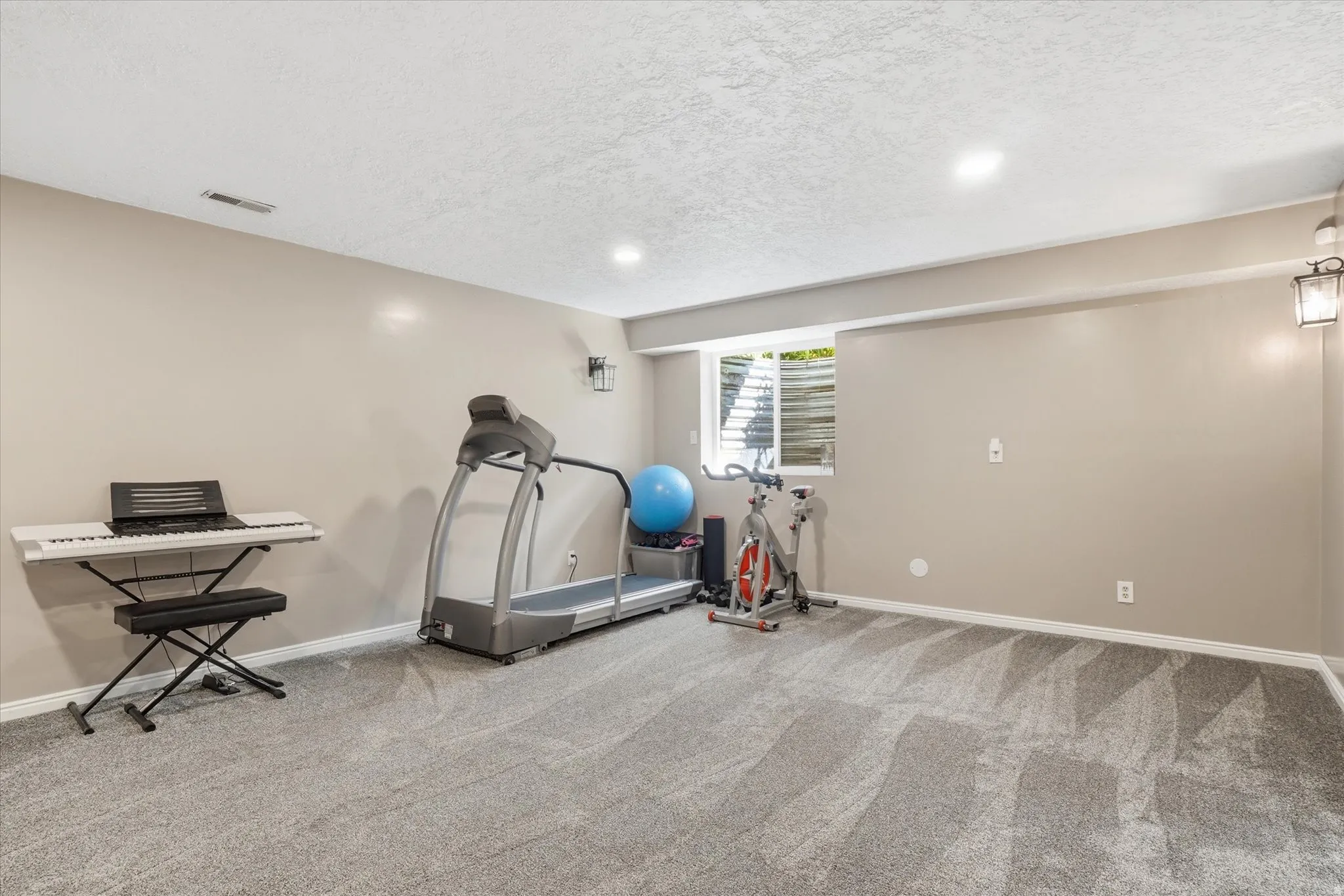 Exercise area featuring a textured ceiling, light carpet, and recessed lighting