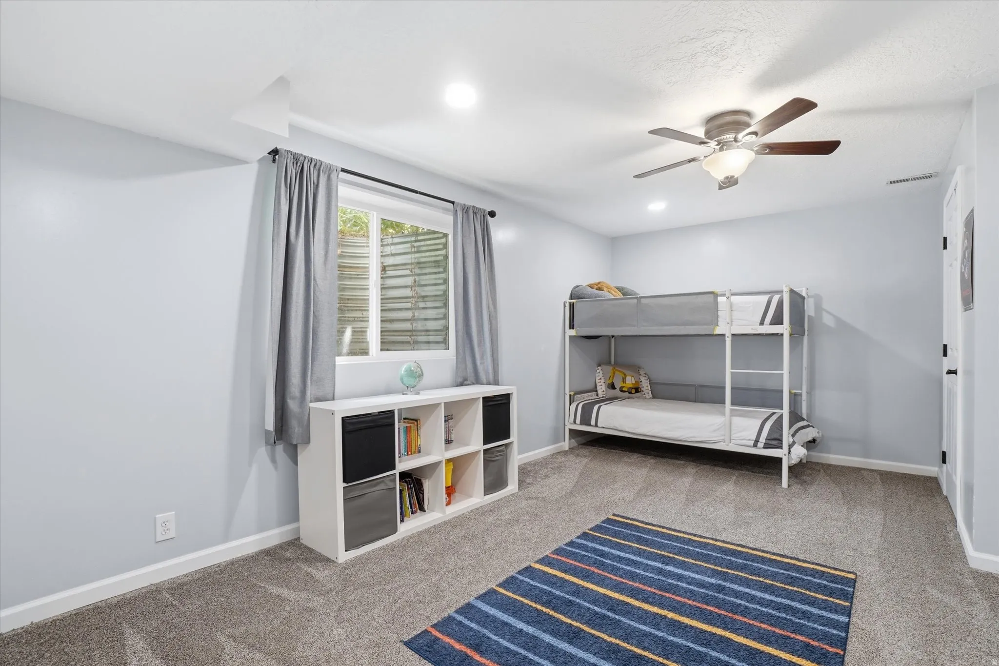 Bedroom with light carpet, ceiling fan, and recessed lighting