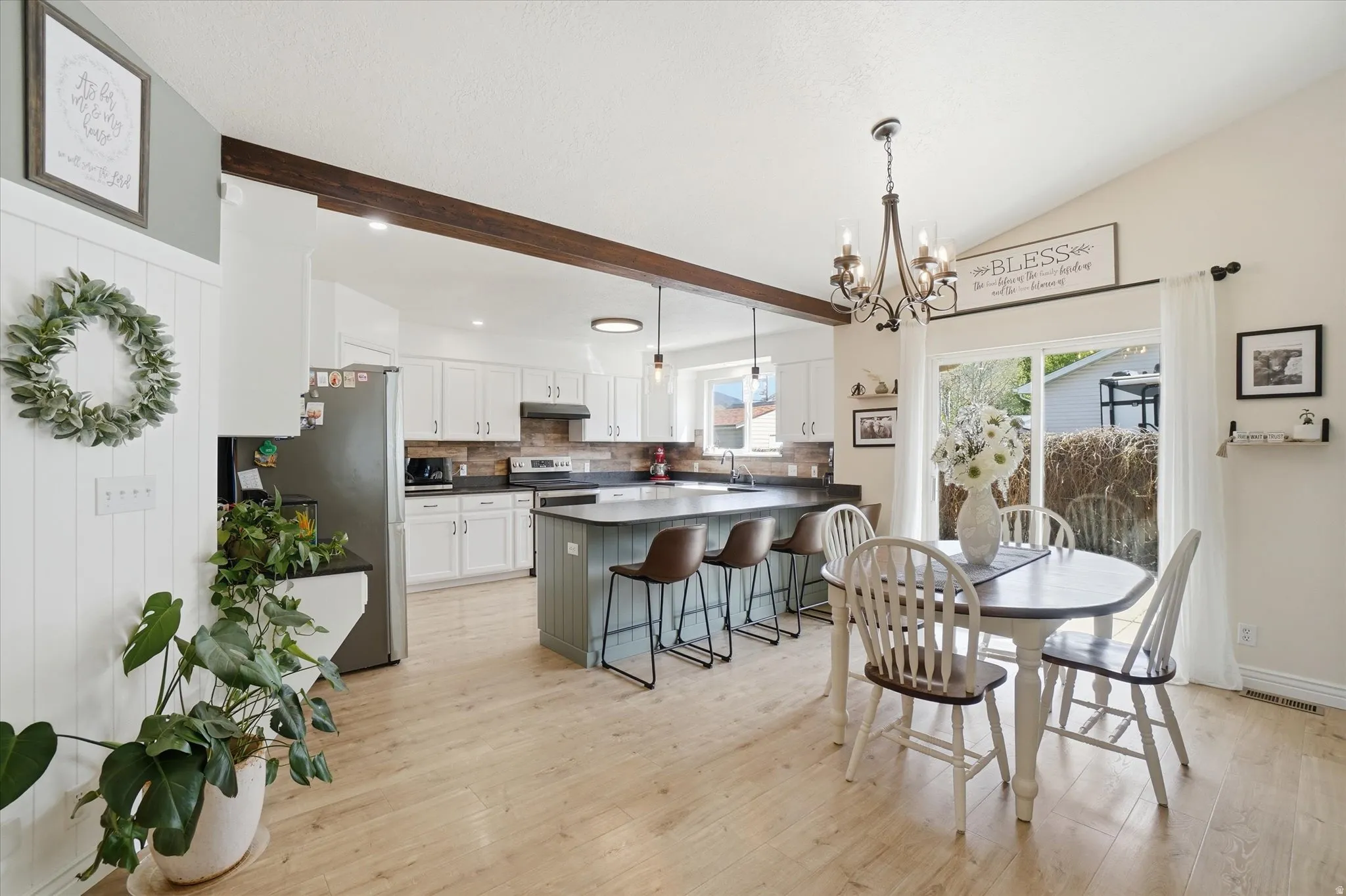 Dining area featuring light wood finished floors, a chandelier, and lofted ceiling
