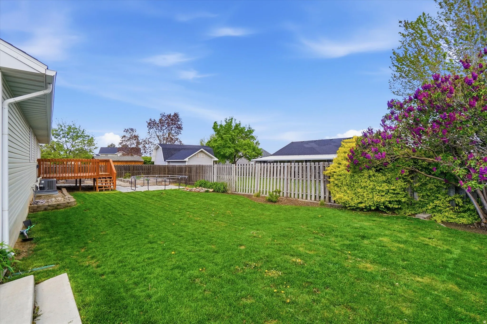 Fenced backyard featuring a deck