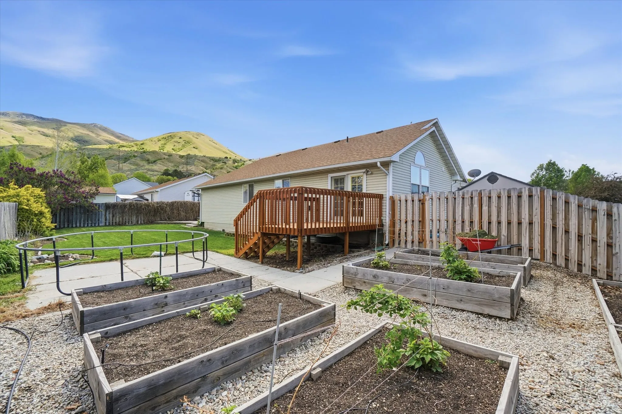 Back of property with a deck, mountain view and a garden
