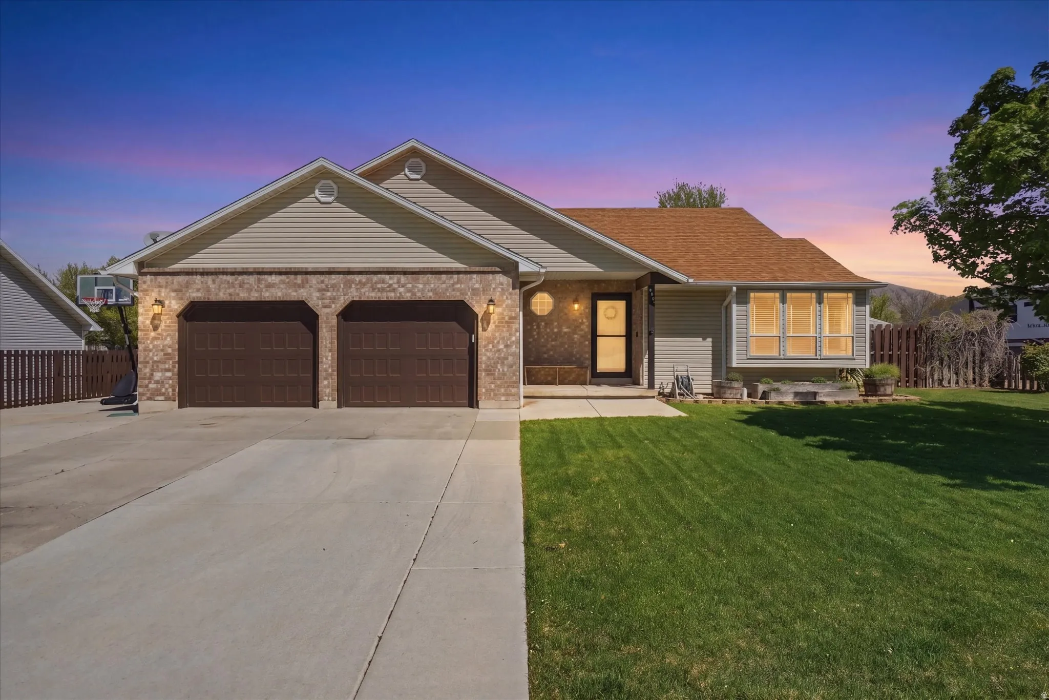 Ranch-style house with an attached garage, brick siding, concrete driveway, and roof with shingles