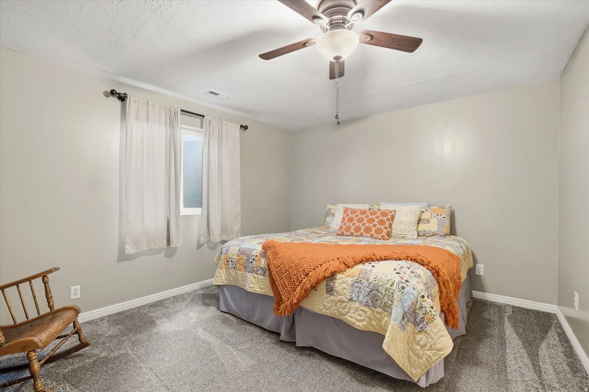 Carpeted bedroom featuring baseboards and ceiling fan