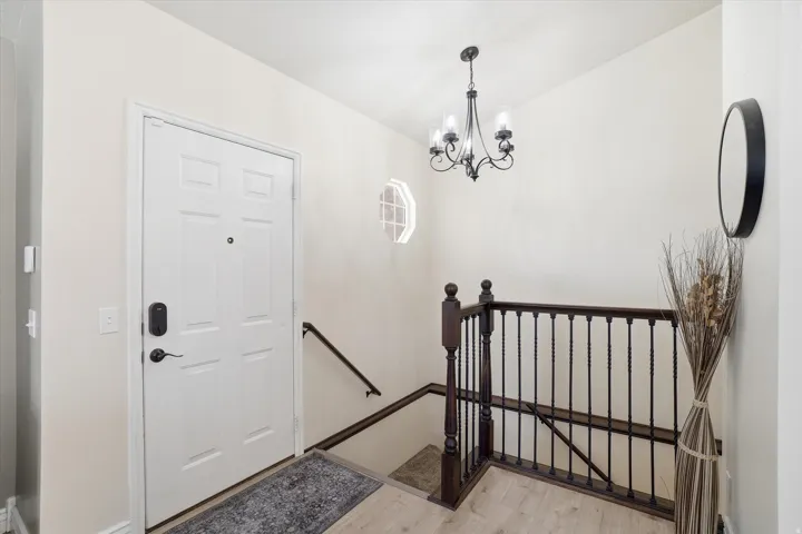 Entrance foyer featuring light wood-style flooring and a chandelier