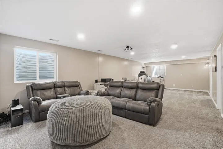 Carpeted home theater room with baseboards