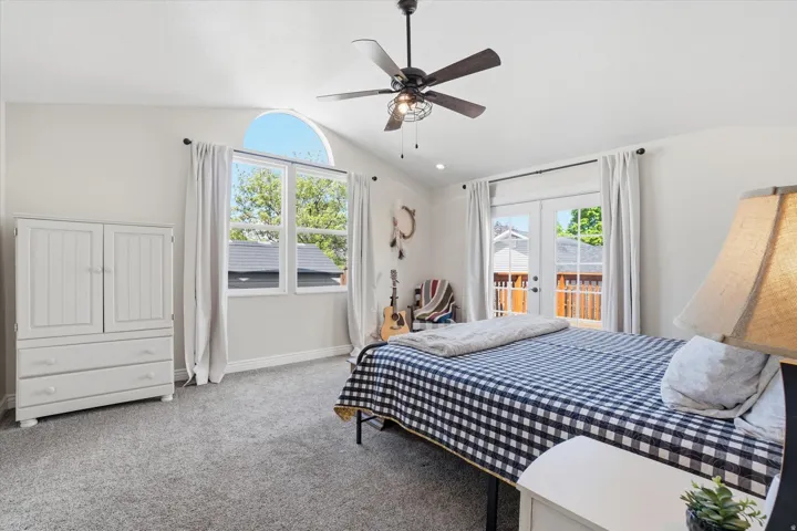 Carpeted bedroom featuring french doors, access to exterior, and ceiling fan