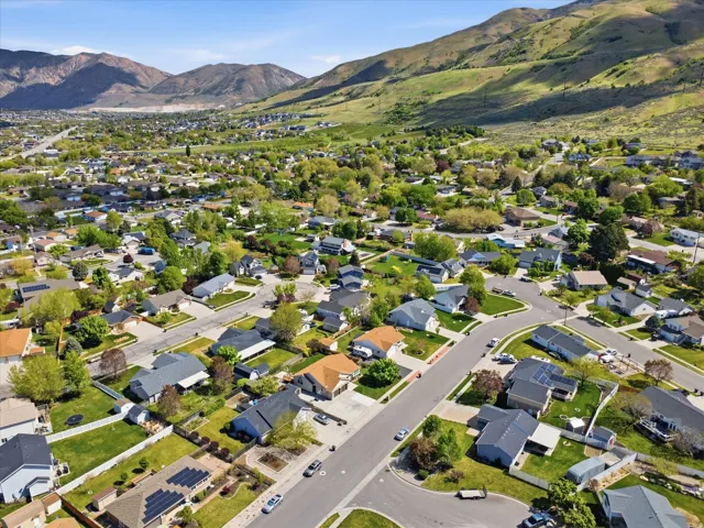 Aerial view of property's location with a mountain backdrop and nearby suburban area
