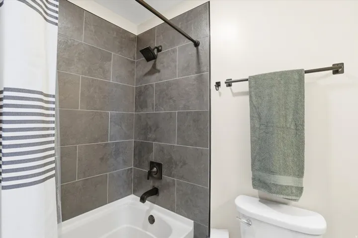 Bathroom featuring toilet and shower / tub combo