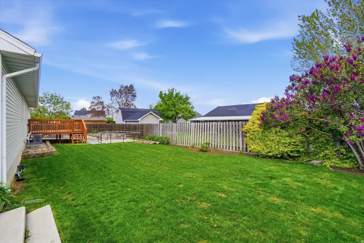 Fenced backyard featuring a deck