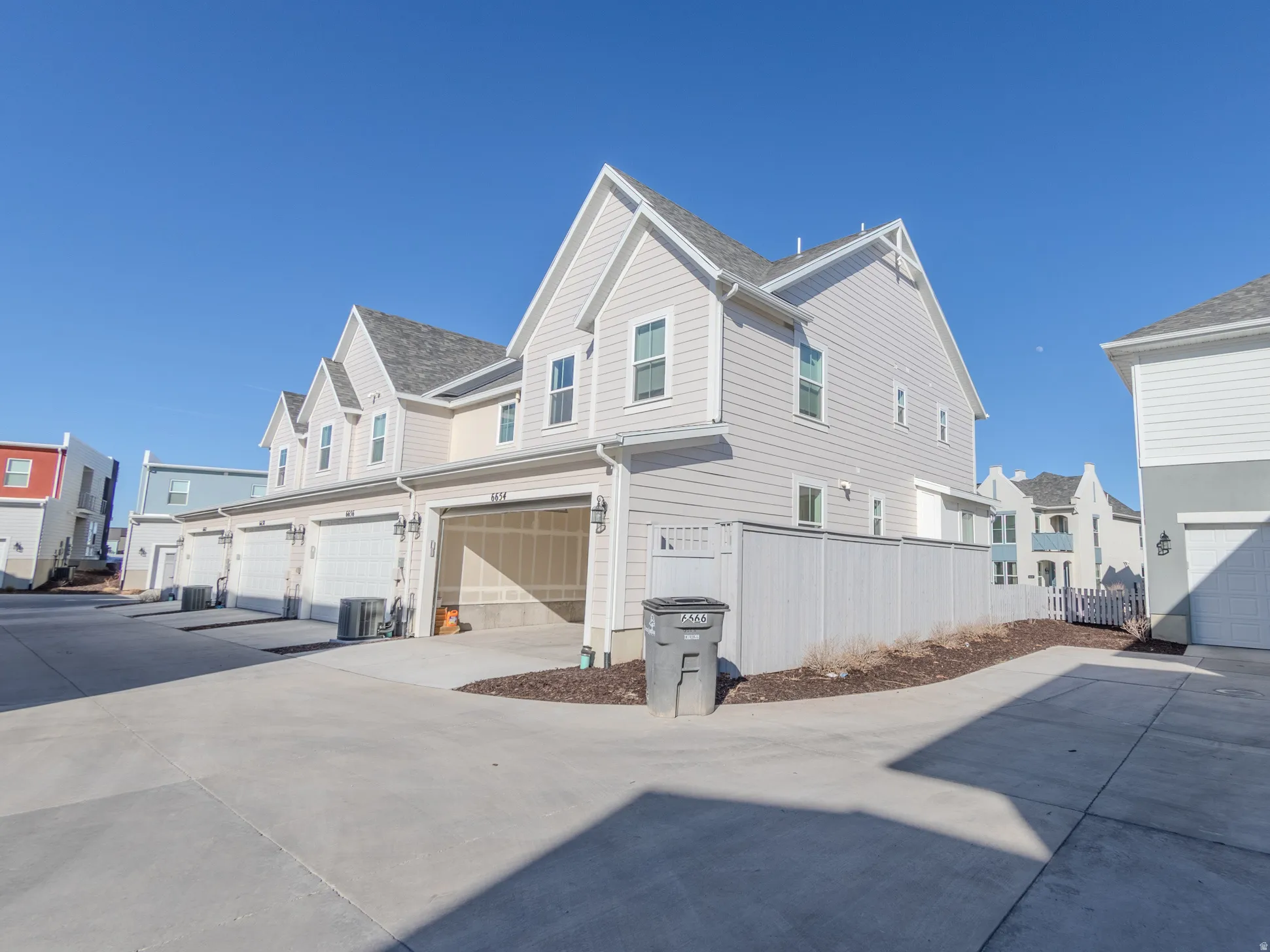 View of side of property with a residential view, a garage, and driveway