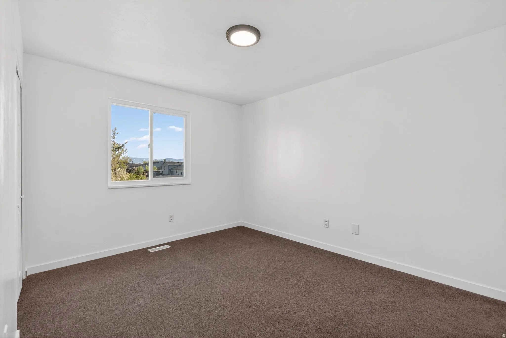 Unfurnished room with baseboards and dark carpet