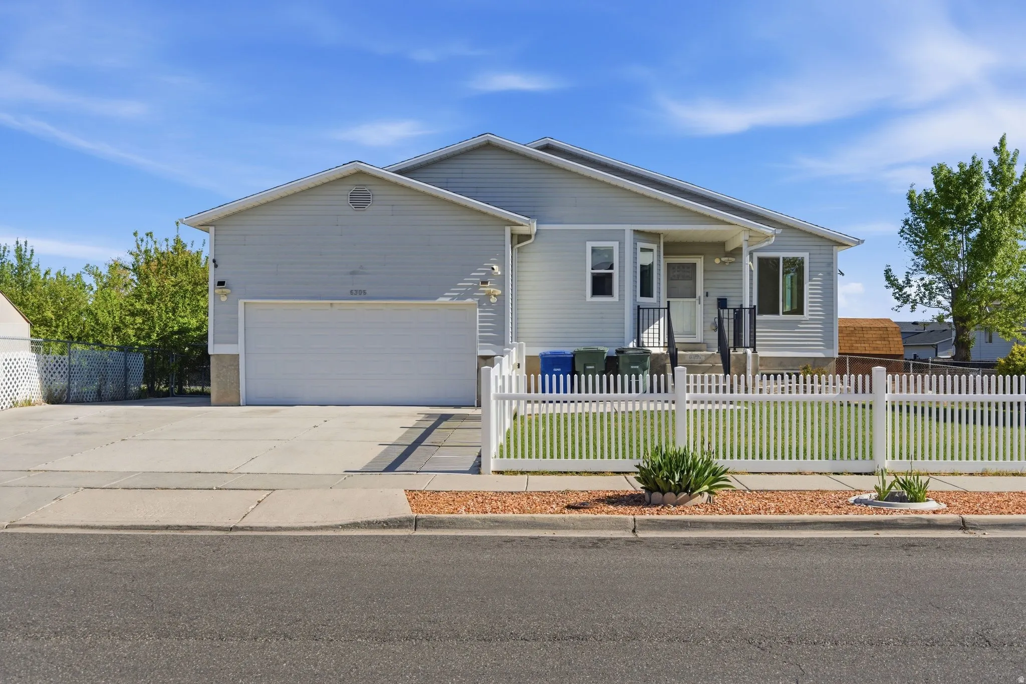 Ranch-style home with a fenced front yard, driveway, and a garage