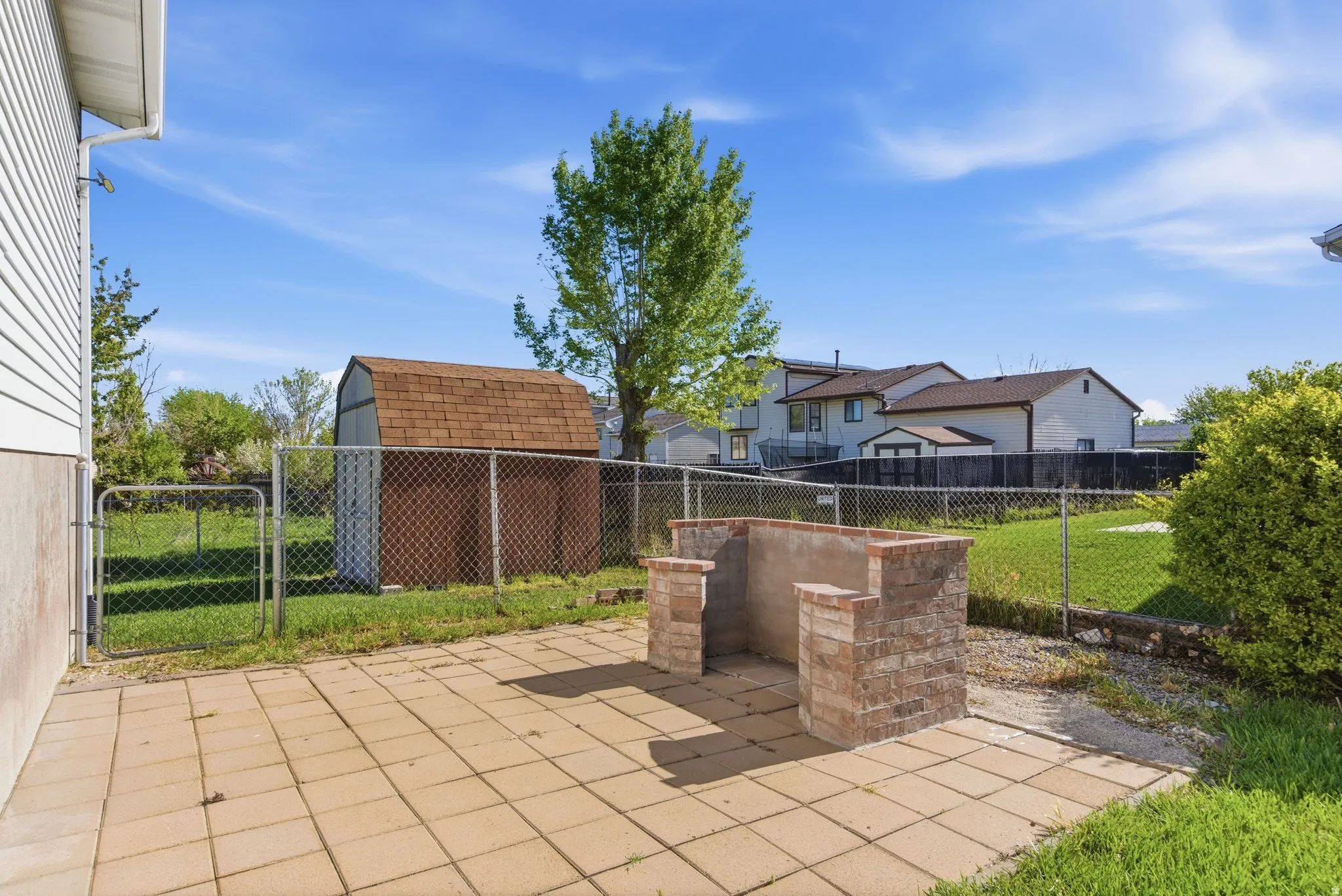 Fenced backyard featuring a patio area and a gate