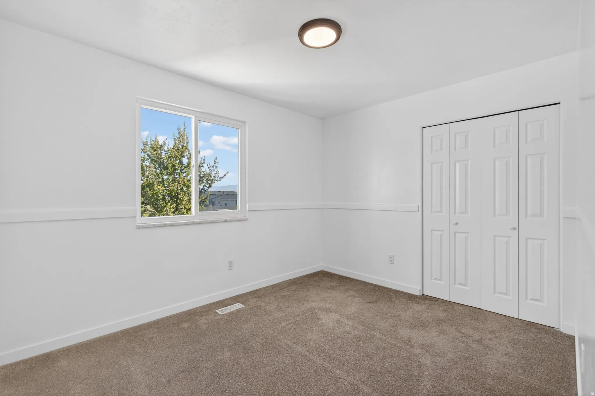 Unfurnished bedroom with dark carpet and a closet