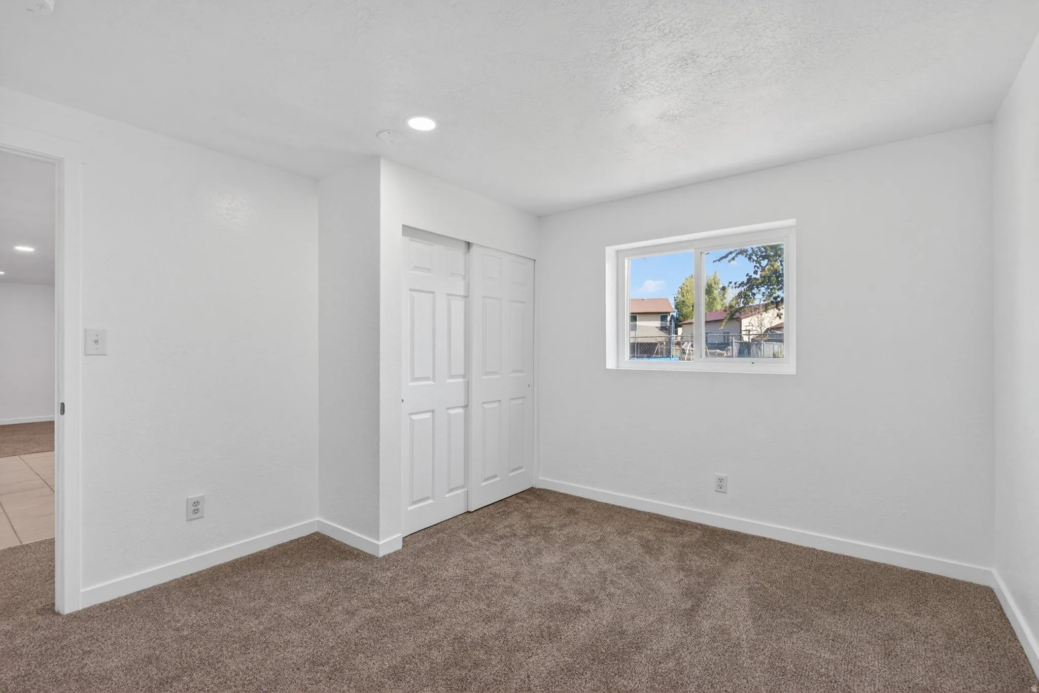 Unfurnished bedroom with carpet floors, a closet, and recessed lighting