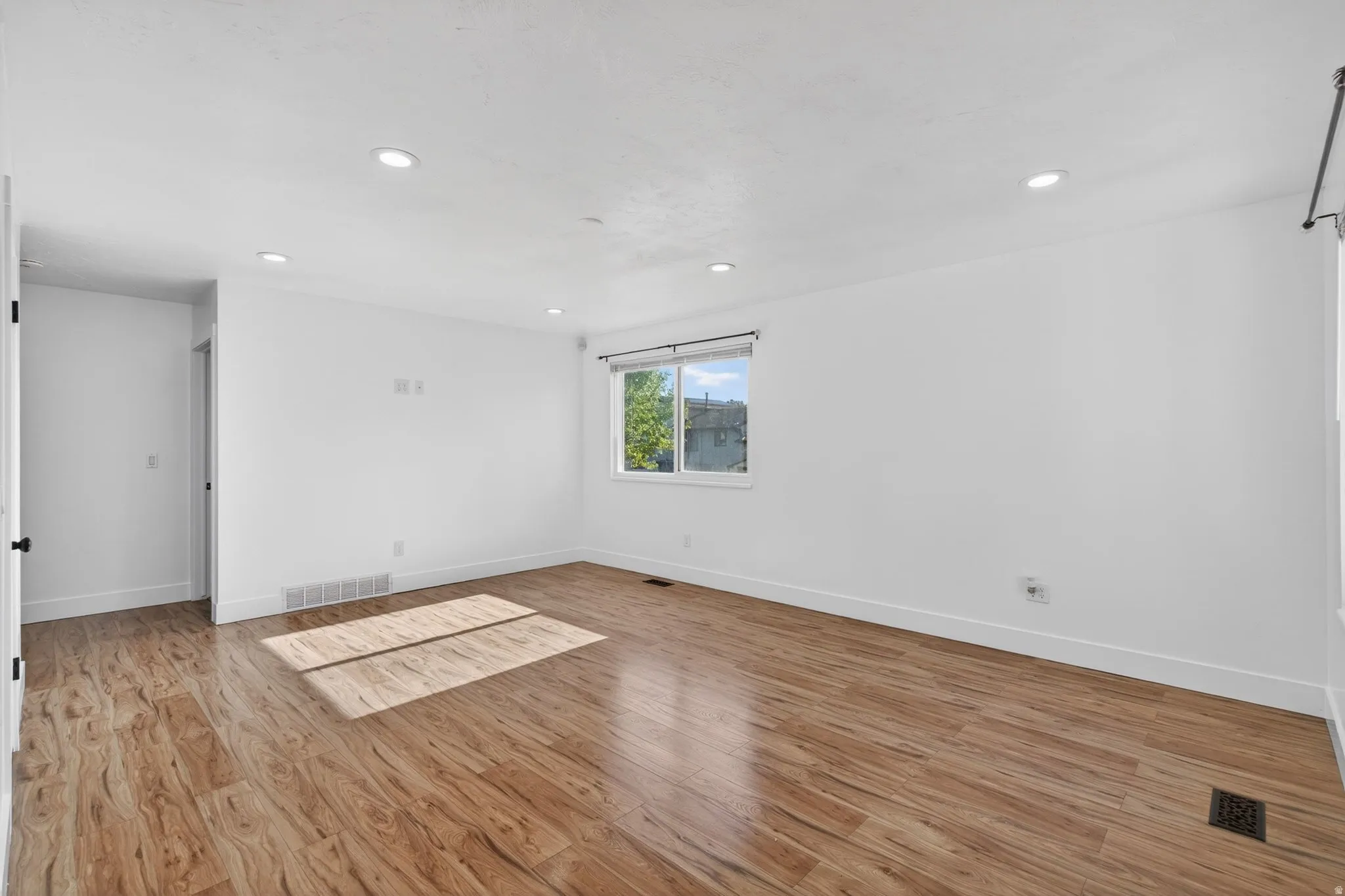 Spare room with light wood finished floors and recessed lighting