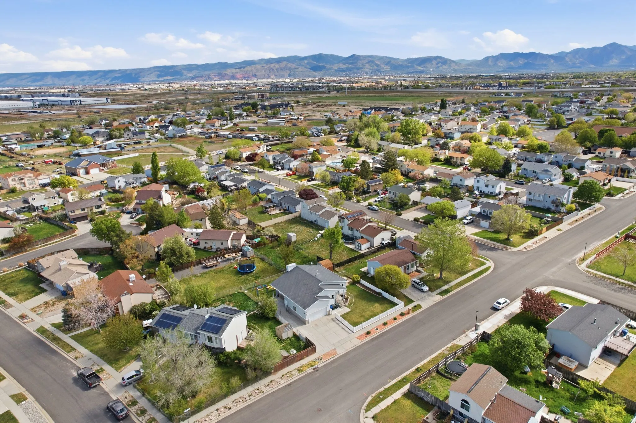 Aerial view of property and surrounding area with nearby suburban area and mountains