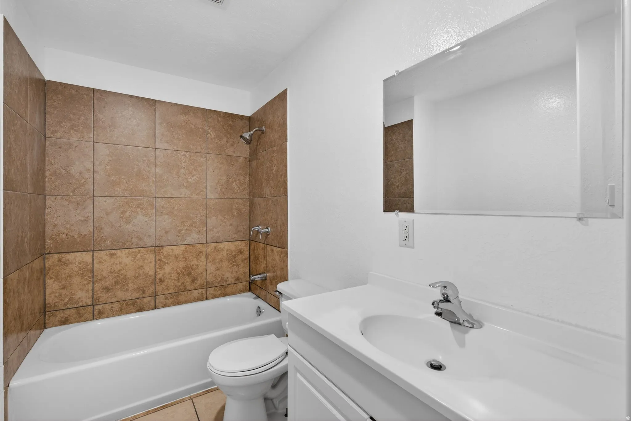 Full bath featuring vanity,  shower combination, and light tile patterned floors