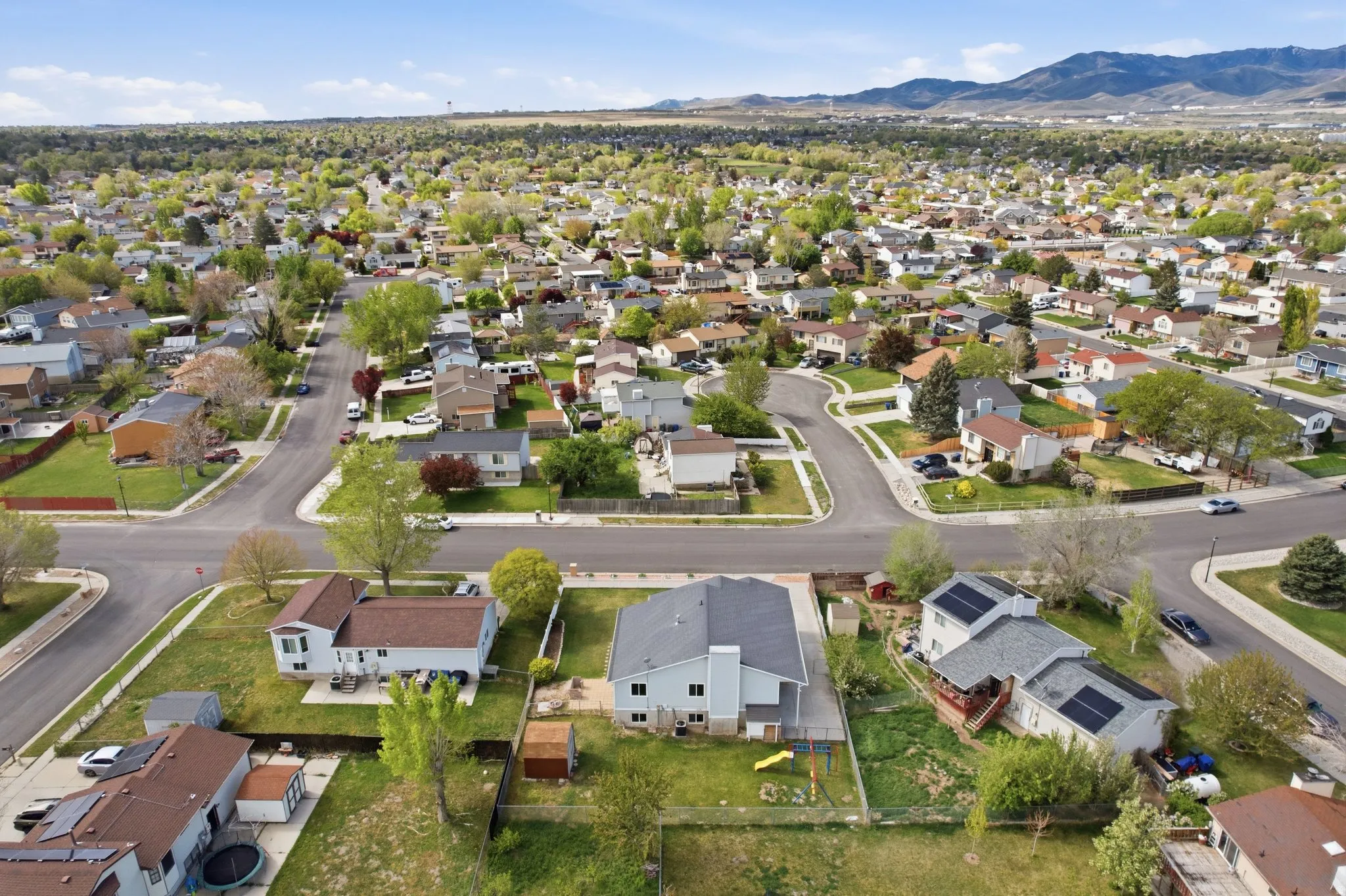 Aerial view of property's location with nearby suburban area and a mountain backdrop