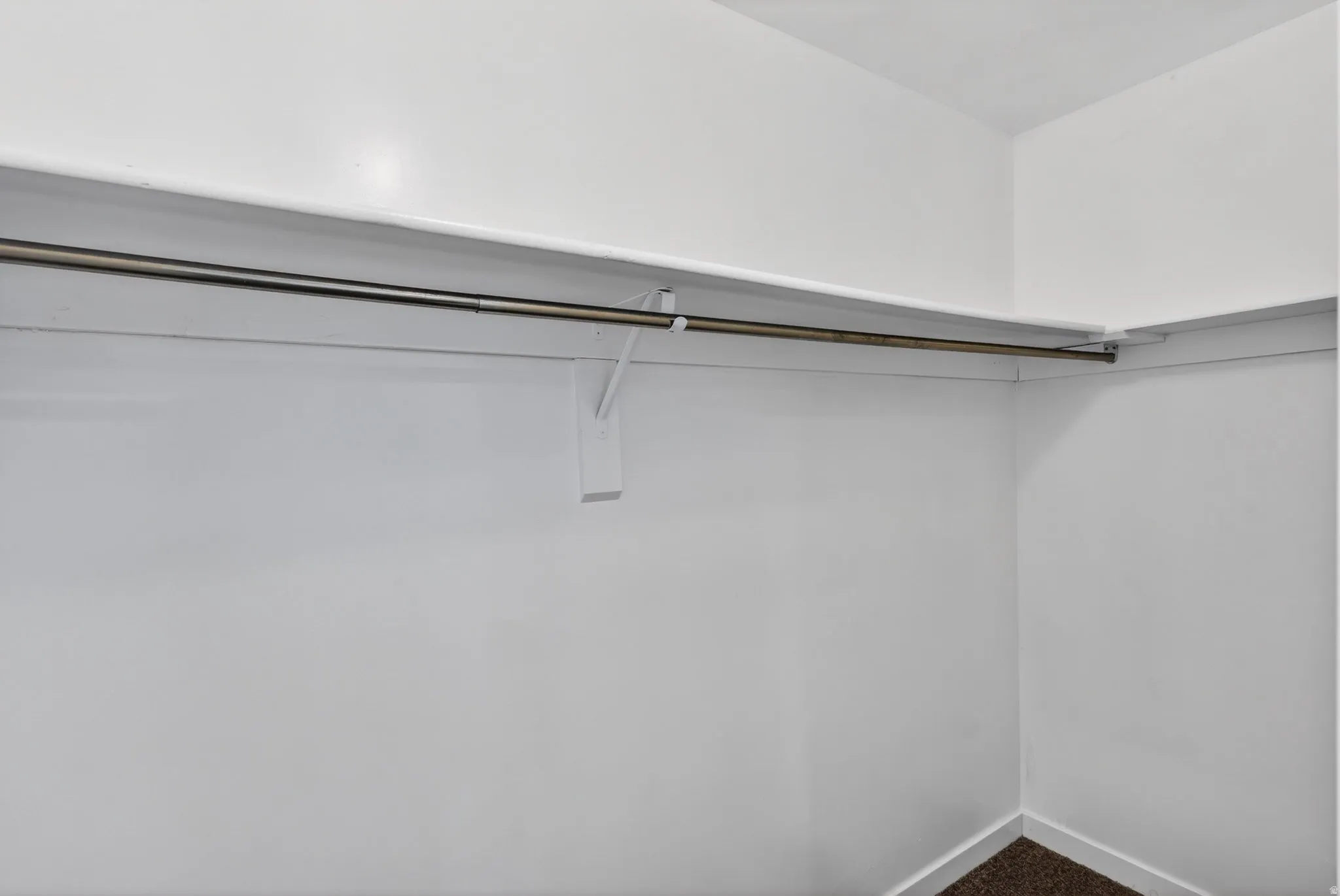 Walk in closet featuring dark colored carpet
