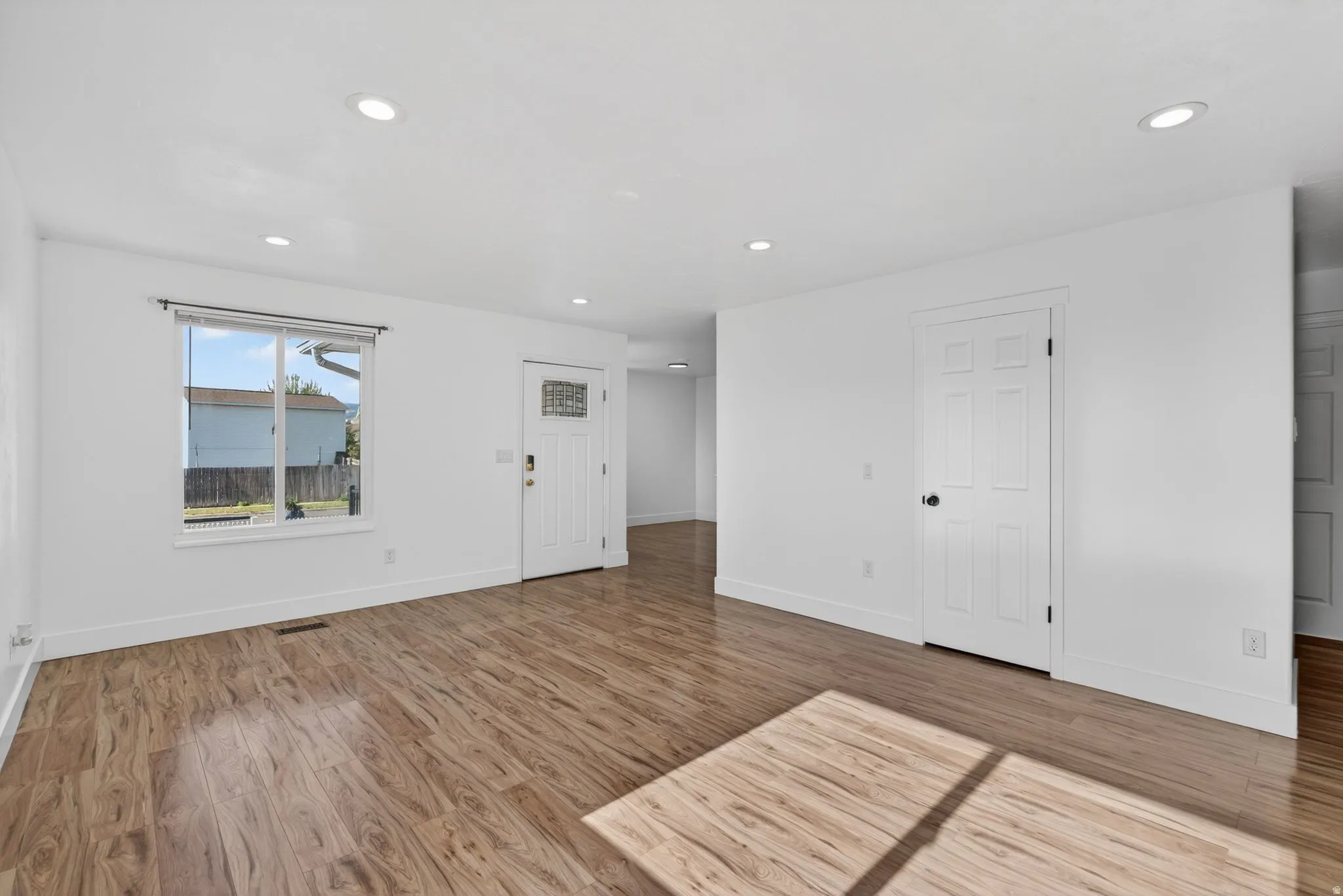 Empty room featuring light wood finished floors and recessed lighting