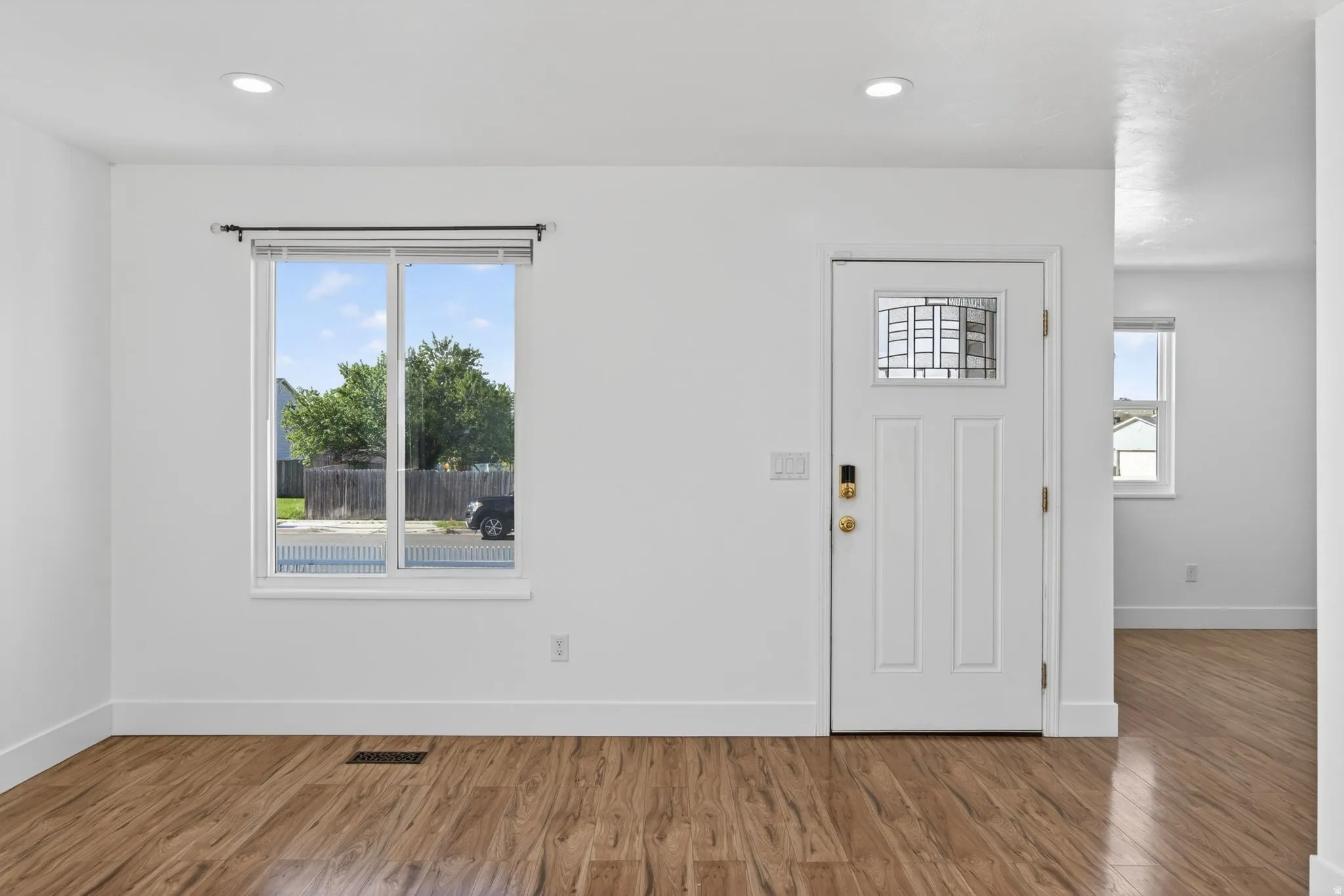 Entryway with wood finished floors and recessed lighting