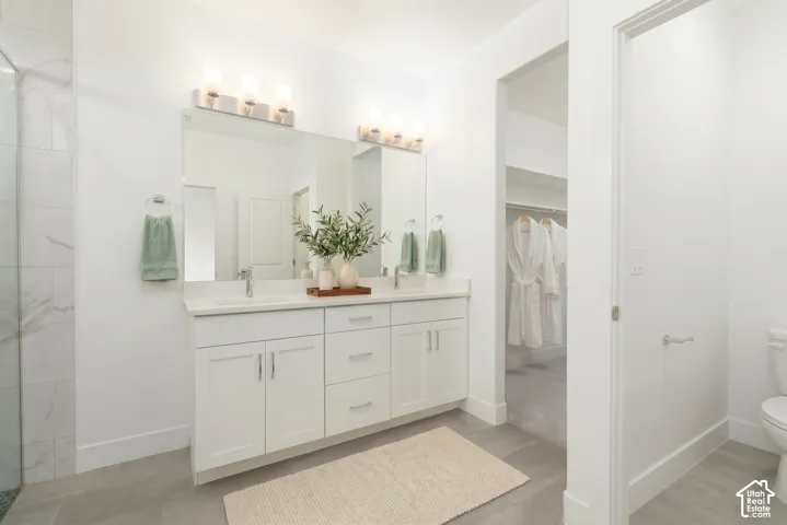 Dual vanity with white cabinetry, polished chrome hardware, and white countertops
