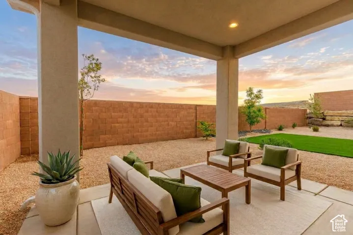 Covered patio featuring recessed lighting, a gravel-covered yard, a block wall perimeter, and a strip of artificial turf