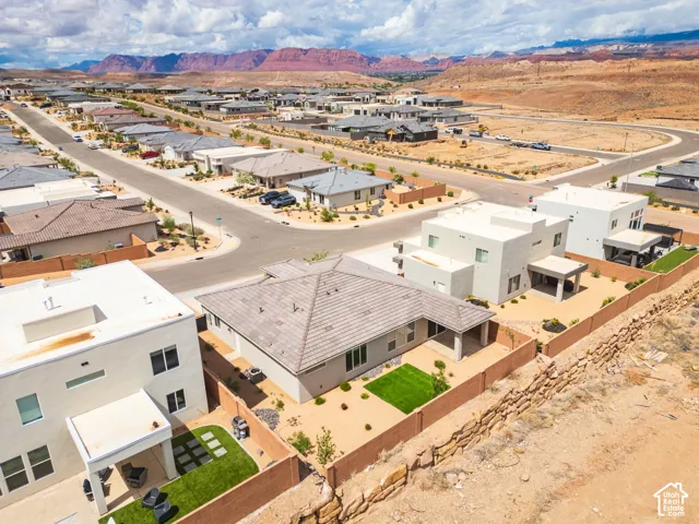 Aerial perspective featuring a residential neighborhood with arid landscaping and a backdrop of red rock formations