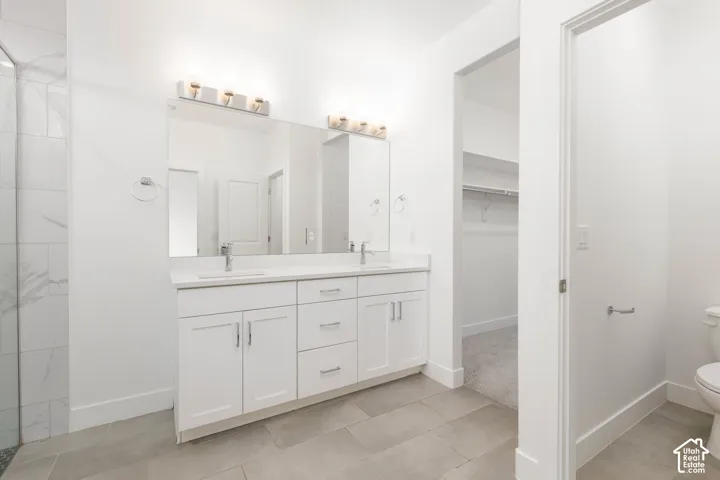 Dual vanity with white cabinetry, quartz countertop, and undermount sinks