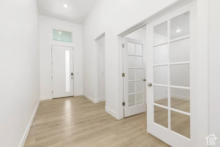 Entryway featuring wood-finish flooring, a contemporary front door with frosted glass, and a transom window