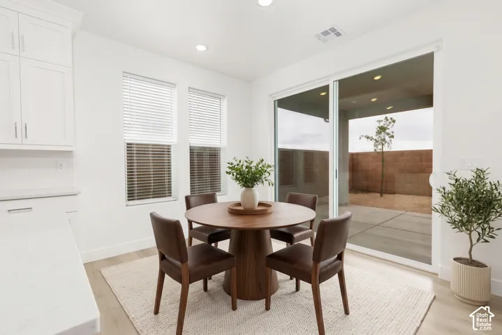 White cabinetry, light wood-finish flooring, and a sliding glass door