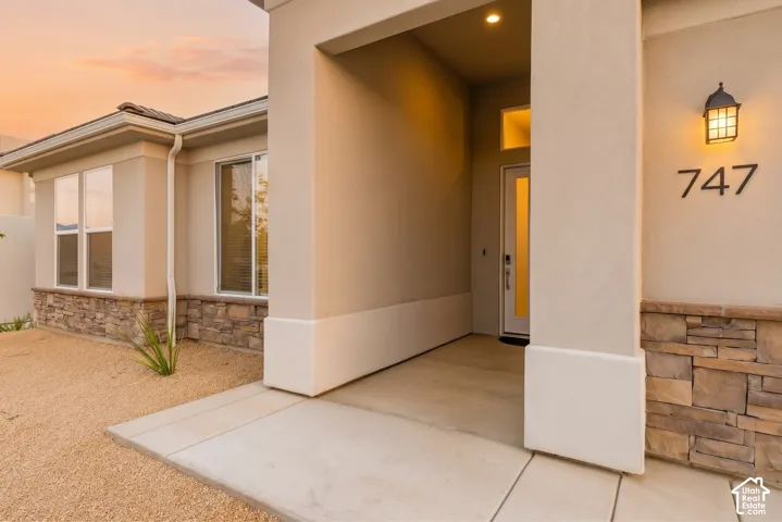 Stucco exterior with stone accent detailing, covered entry, and a prominent entry door