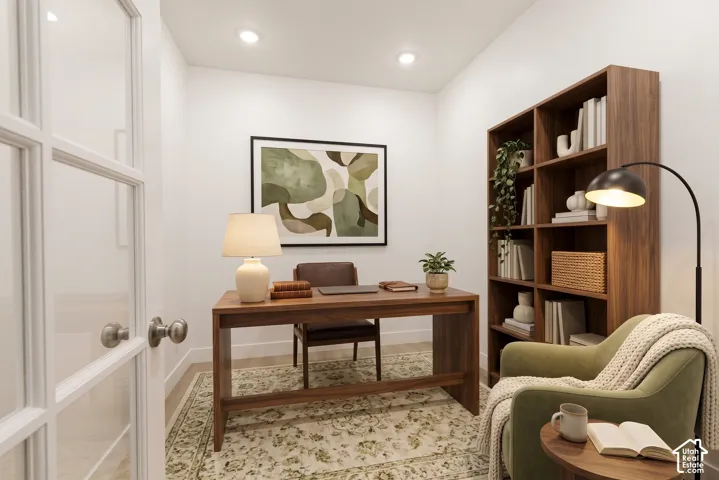 French doors with glass panels, recessed ceiling lighting, a built-in wood-finish bookcase, and wood-finish flooring