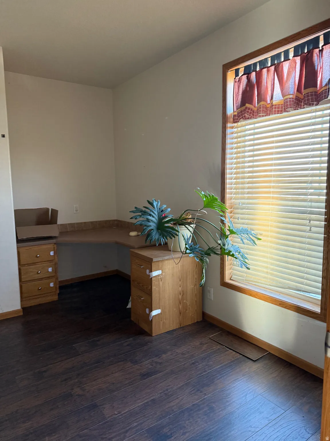 Unfurnished office with baseboards and dark wood-style floors