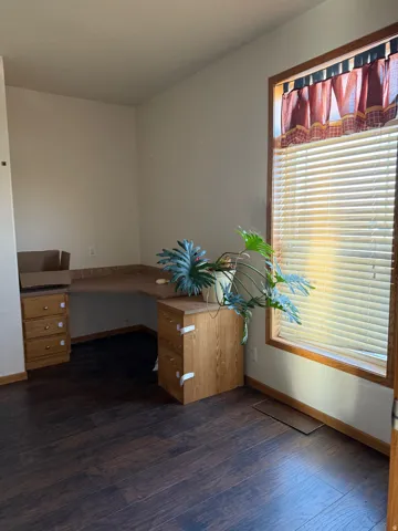 Unfurnished office with baseboards and dark wood-style floors