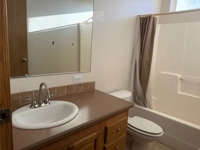 Bathroom with vanity and shower / bath combination with curtain