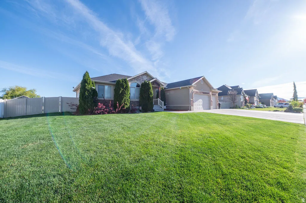 Ranch-style home featuring stucco siding, an attached garage, and driveway