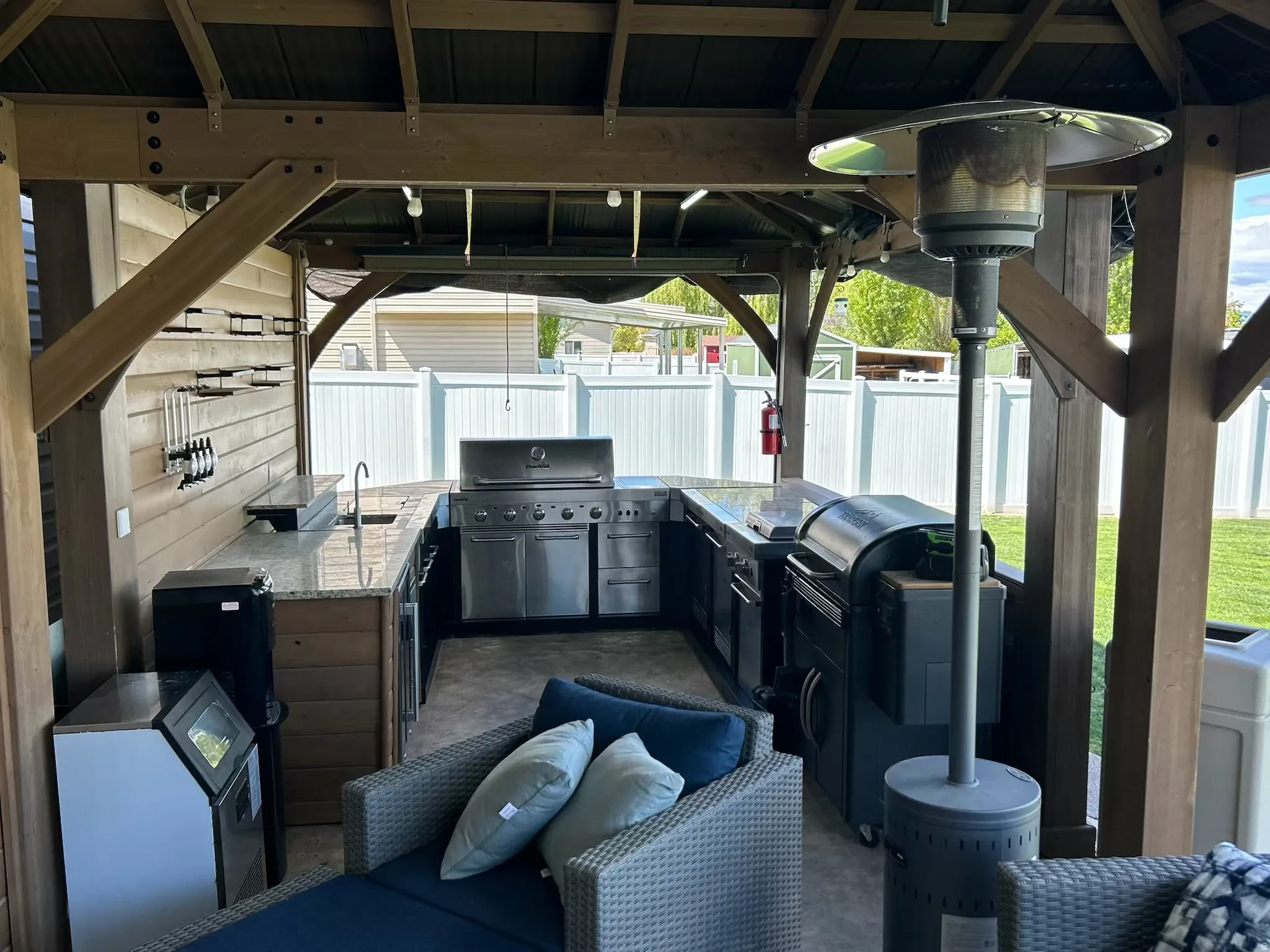 Fenced backyard featuring area for grilling, a gazebo, a patio area, and washer and clothes dryer