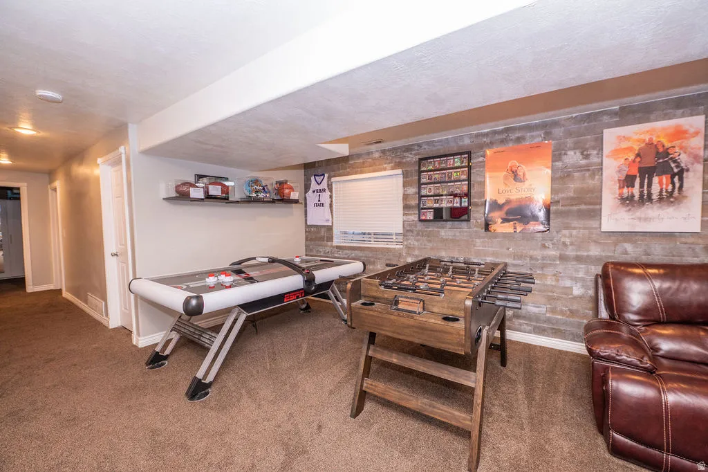 Rec room featuring carpet floors and a textured ceiling