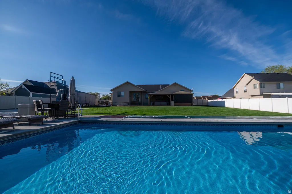 View of pool featuring a fenced backyard and patio surround
