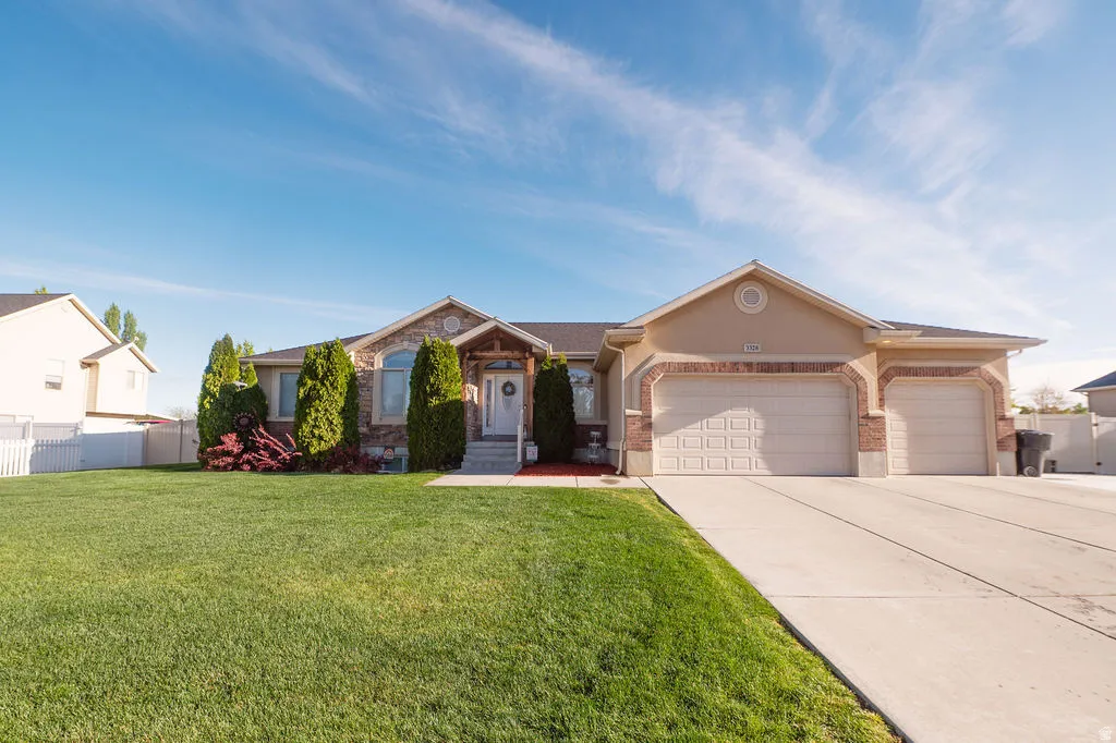 Ranch-style house featuring a garage, brick siding, and concrete driveway