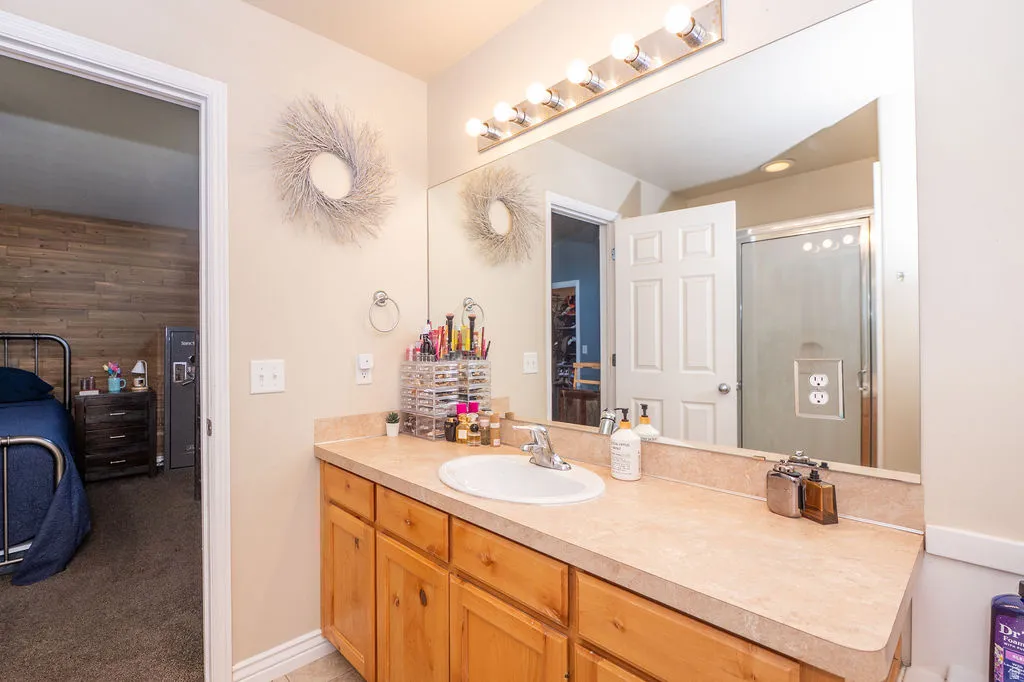 Full bathroom featuring vanity, a shower with shower door, and light carpet