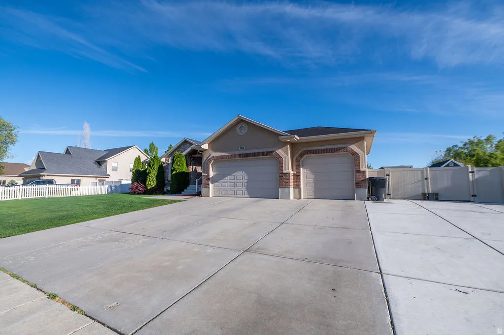Ranch-style home with brick siding, a gate, a garage, and concrete driveway