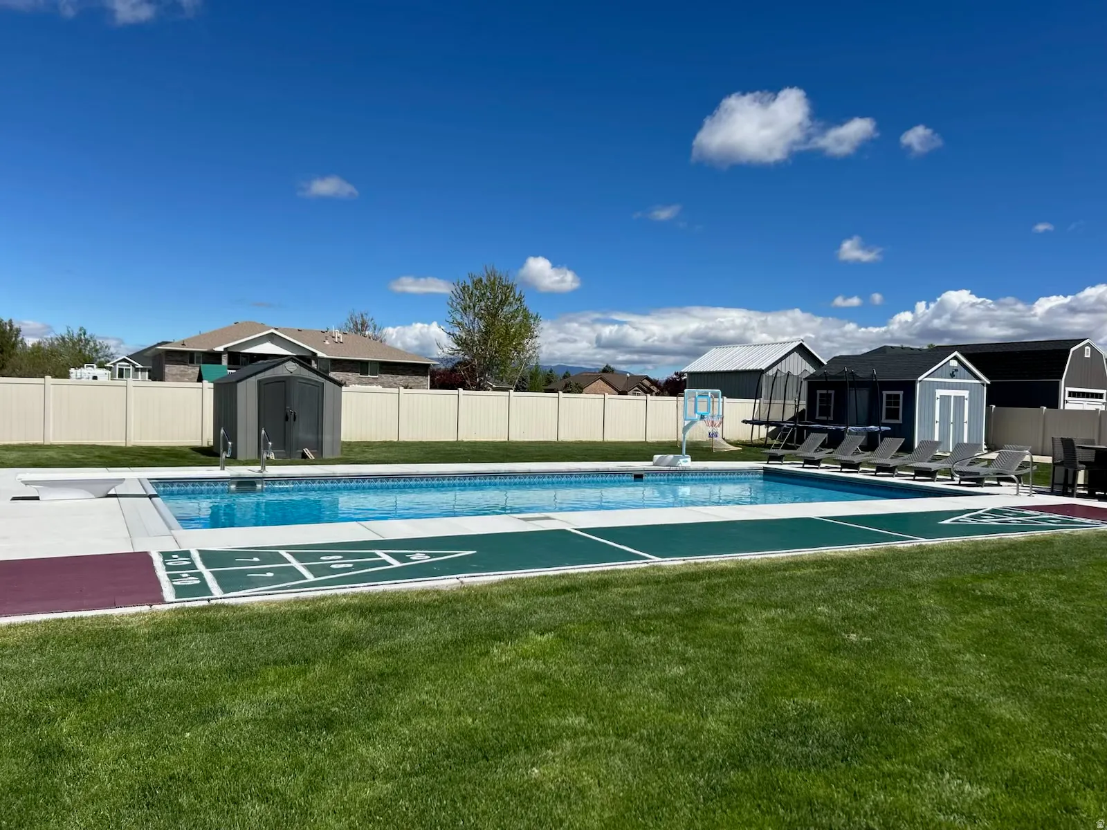 View of pool with a storage shed, patio surround, a fenced backyard, and a residential view