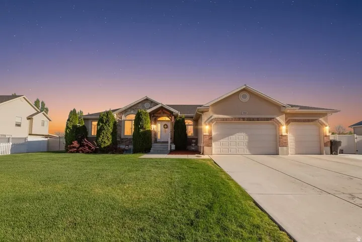 Single story home featuring an attached garage, concrete driveway, and brick siding