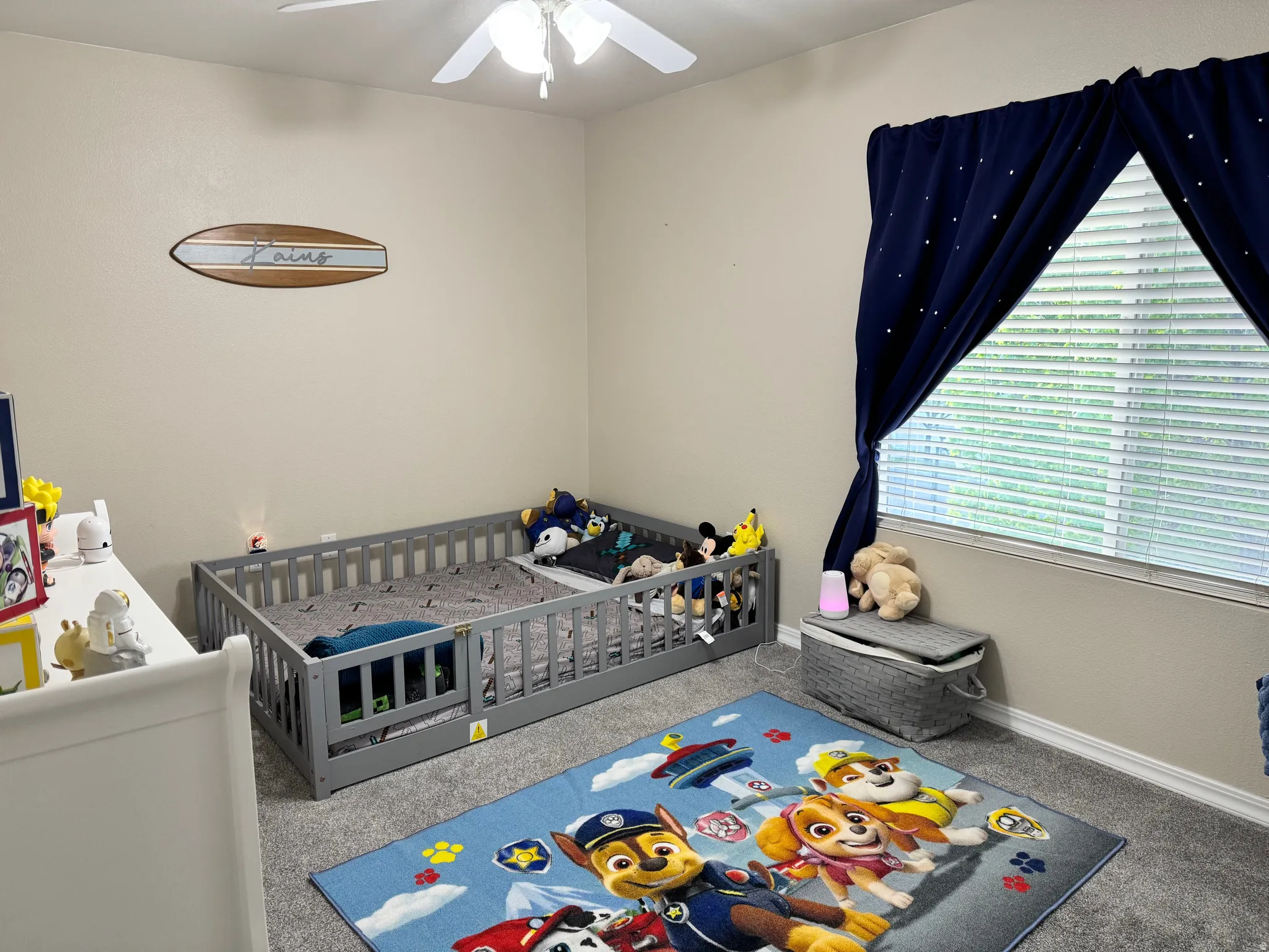 Bedroom featuring carpet floors, a nursery area, and ceiling fan