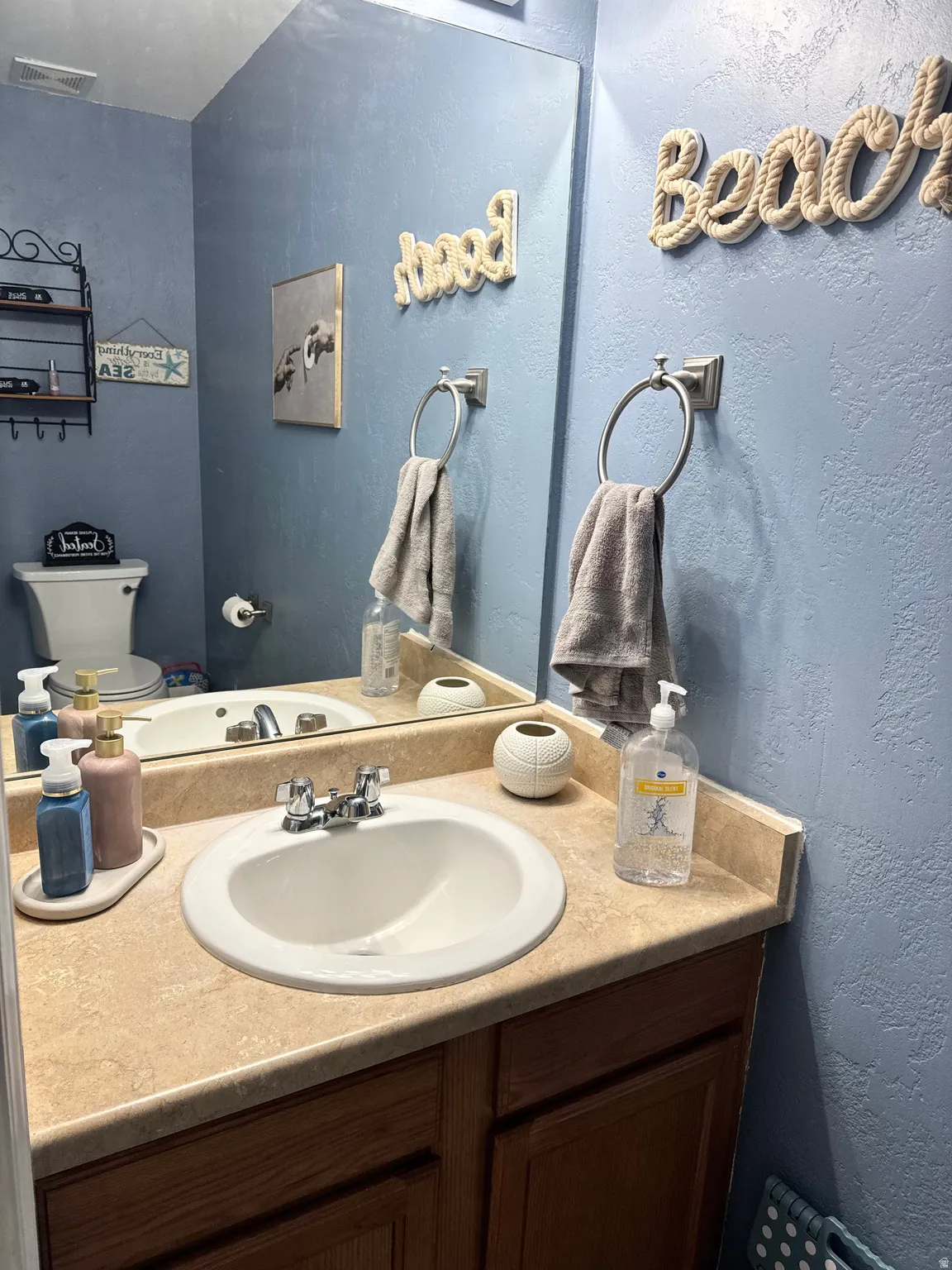 Half bathroom with a textured wall and vanity