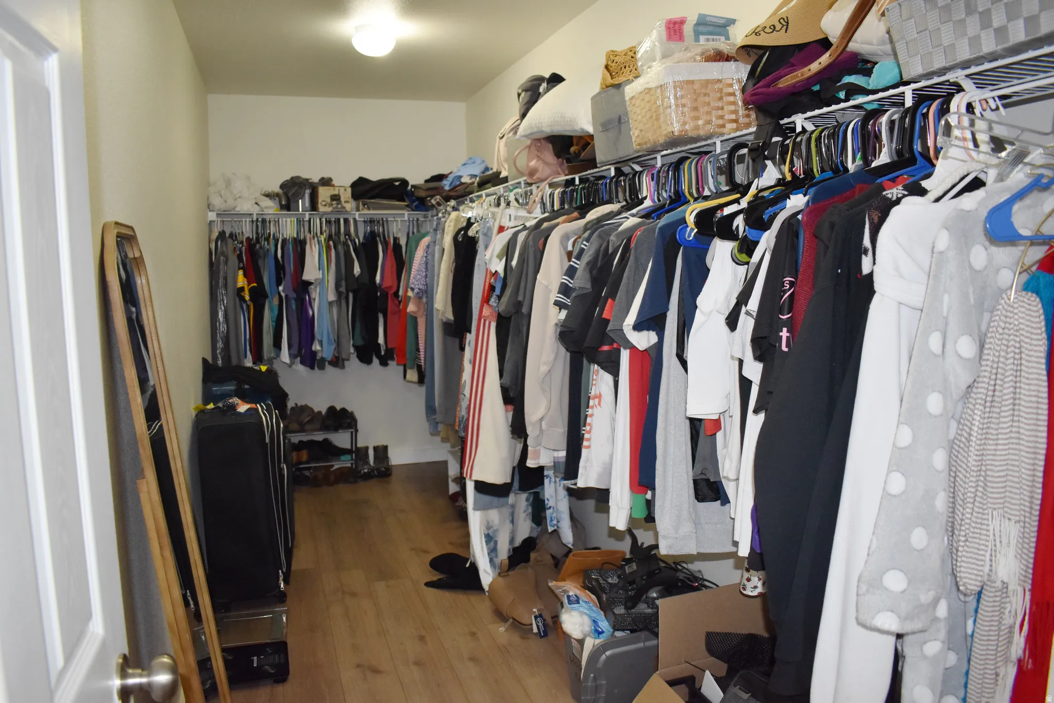 Walk in closet with wood finished floors